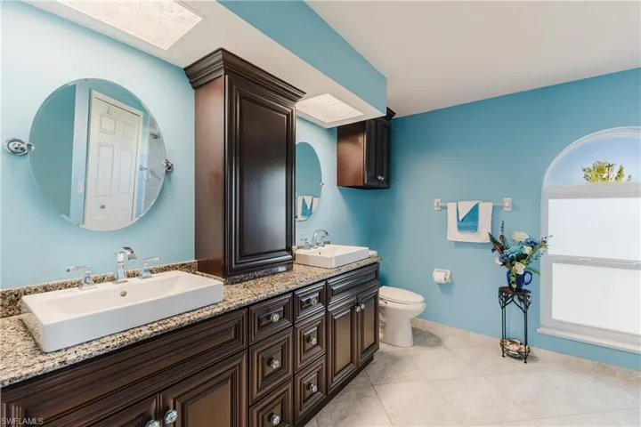 Bathroom with double vanity and light tile patterned floors