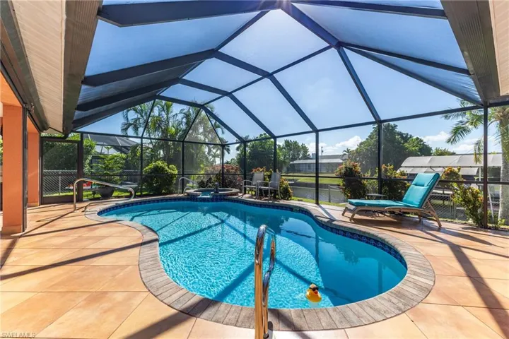 View of swimming pool with a sunroom, a lanai, a patio area, and a pool with connected hot tub