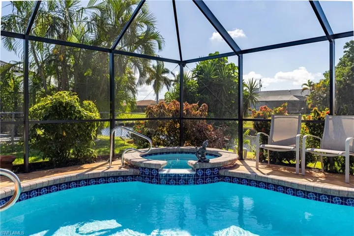 View of swimming pool featuring a sunroom, a pool with connected hot tub, and a lanai