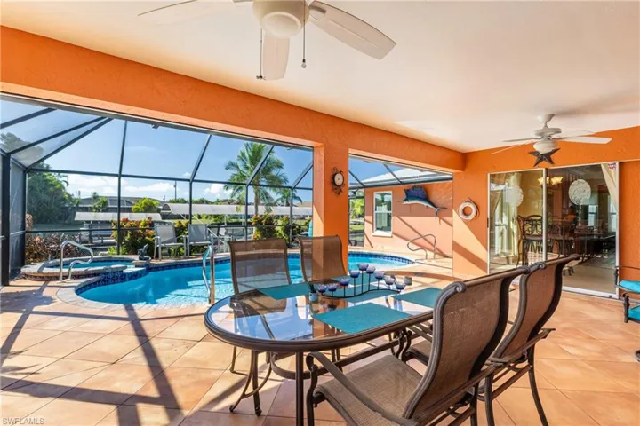View of pool featuring a ceiling fan, a patio area, a sunroom, and a pool with connected hot tub