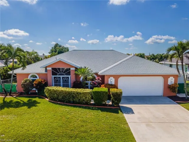 Ranch-style house with a front lawn, concrete driveway, an attached garage, stucco siding, and a shingled roof