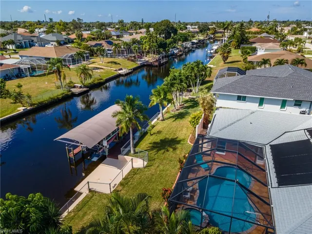 Aerial perspective of suburban area featuring a large body of water and a pool