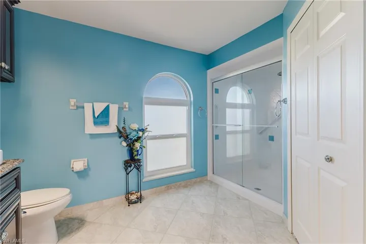 Full bath with a shower stall, light tile patterned flooring, and vanity