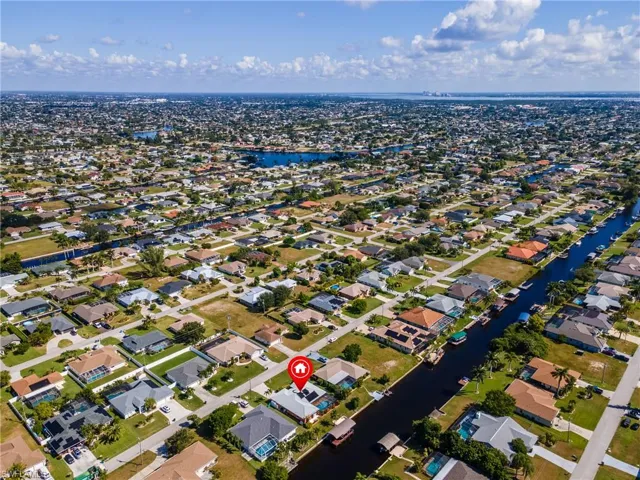 Aerial view of property's location featuring a nearby body of water and nearby suburban area