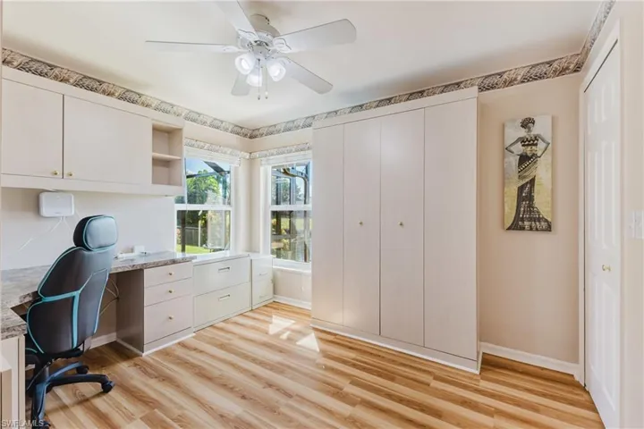Office area featuring Murphy bed light wood finished floors and ceiling fan