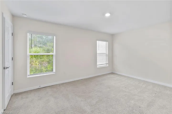Empty room featuring light carpet and baseboards