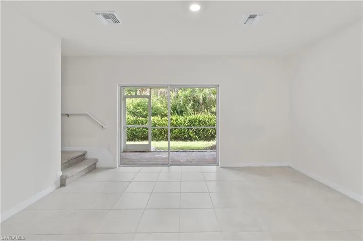 Unfurnished room featuring light tile patterned floors, stairway, and recessed lighting