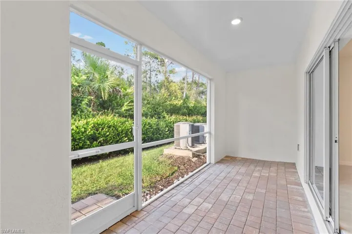Unfurnished sunroom with brick flooring
