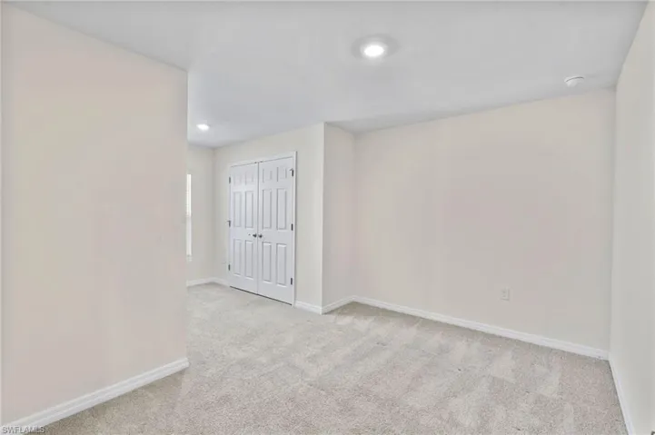 Spare room featuring light colored carpet and recessed lighting
