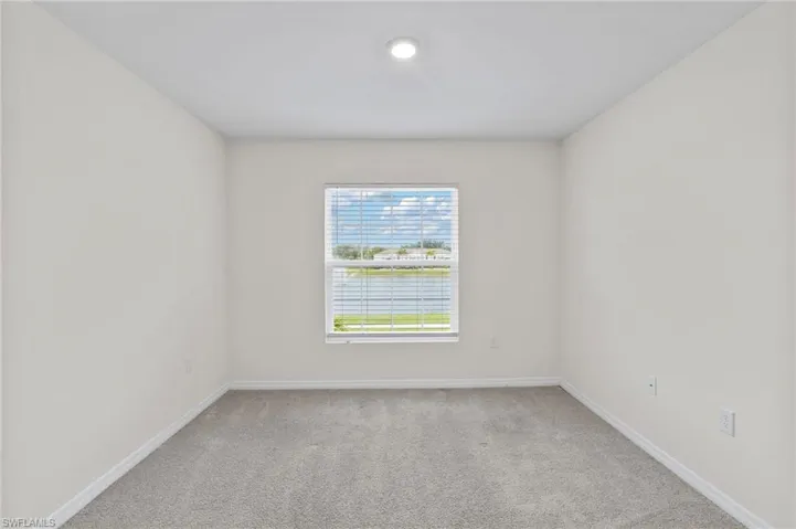 Unfurnished room with light colored carpet and a water view