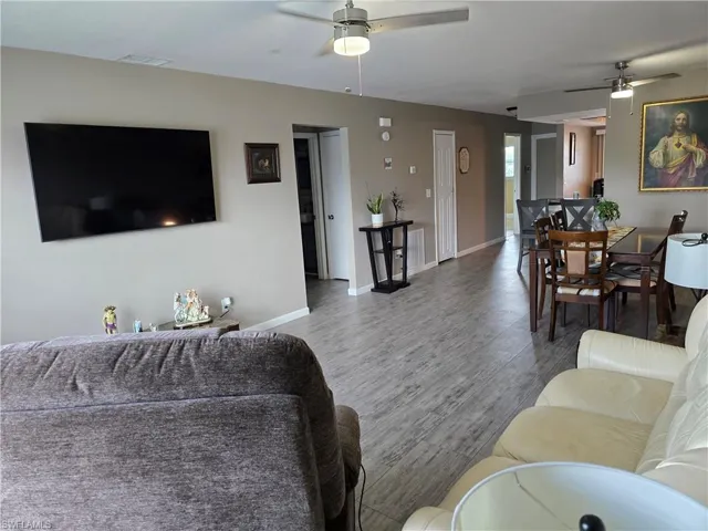 Wood-finish flooring throughout, neutral wall tones, and ceiling fans with integrated lighting