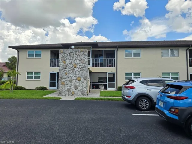 Two-story residential building with stucco siding and a stone veneer accent wall