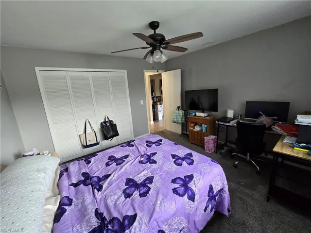 Ceiling fan with integrated lighting, louvered closet doors, and neutral wall paint