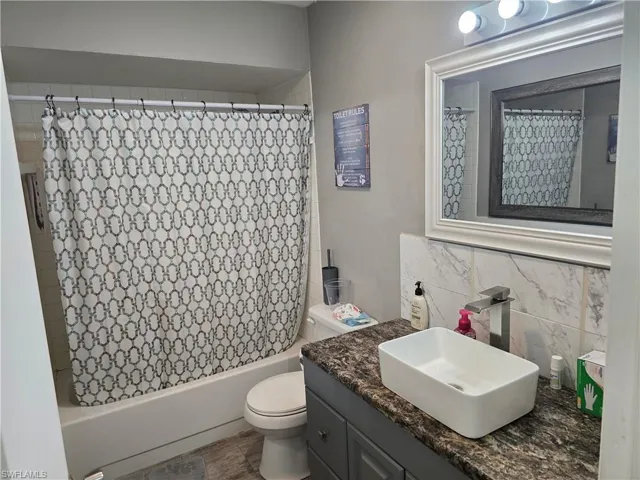 Vanity with a granite-style countertop, rectangular vessel sink, and chrome faucet