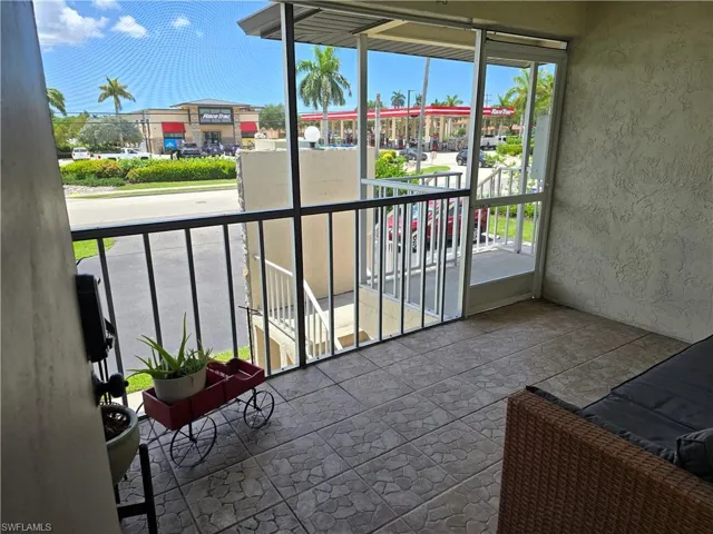 Screened balcony with tiled flooring and metal railings