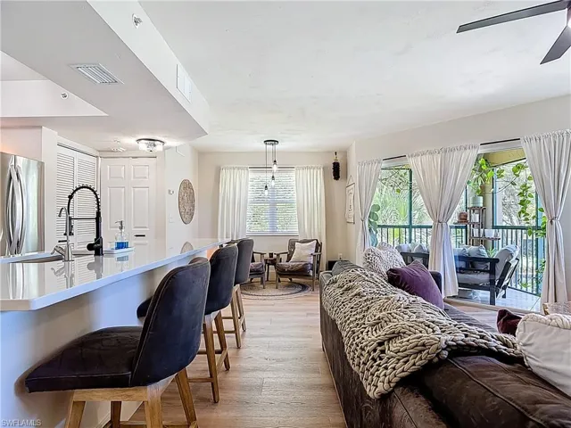 Living area featuring visible vents, light wood-style flooring, and ceiling fan