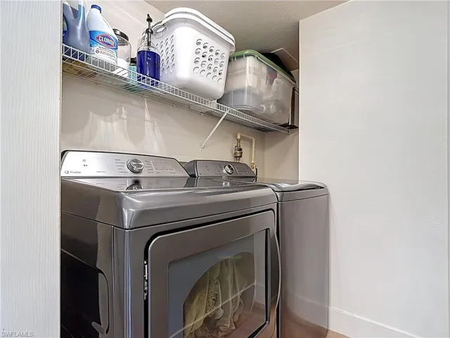 Washroom featuring laundry area and washing machine and clothes dryer