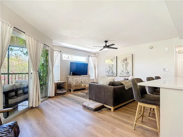 Living area with a wealth of natural light, light wood-type flooring, and a ceiling fan