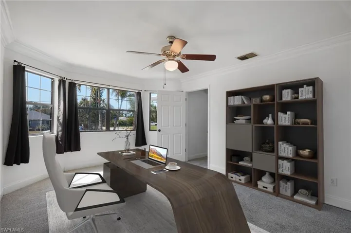 Carpeted office space featuring crown molding, ceiling fan, visible vents, and baseboards