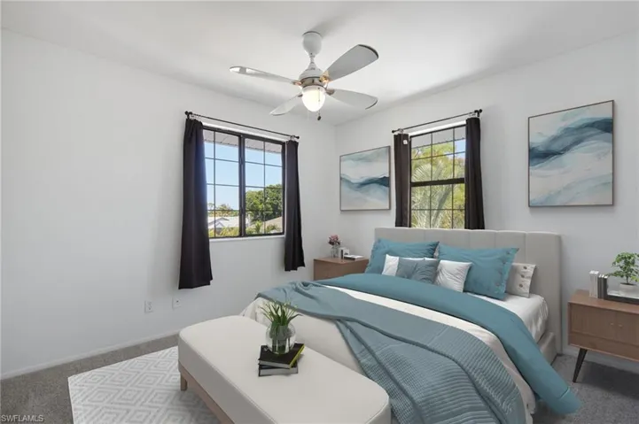 Bedroom with carpet floors, a ceiling fan, baseboards, and multiple windows