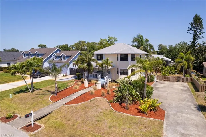 View of front of property featuring fence, a front lawn, a residential view, and concrete driveway