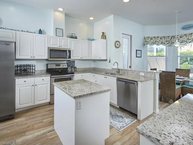 Modern kitchen with stainless steel appliances and quartz countertops.