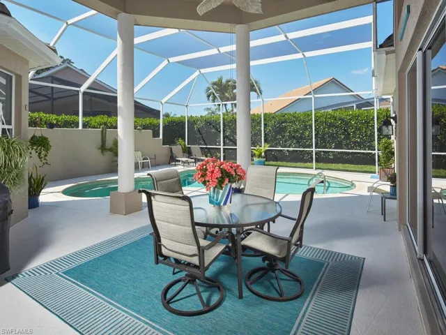 Screened-in lanai with a dining area, perfect for entertaining.