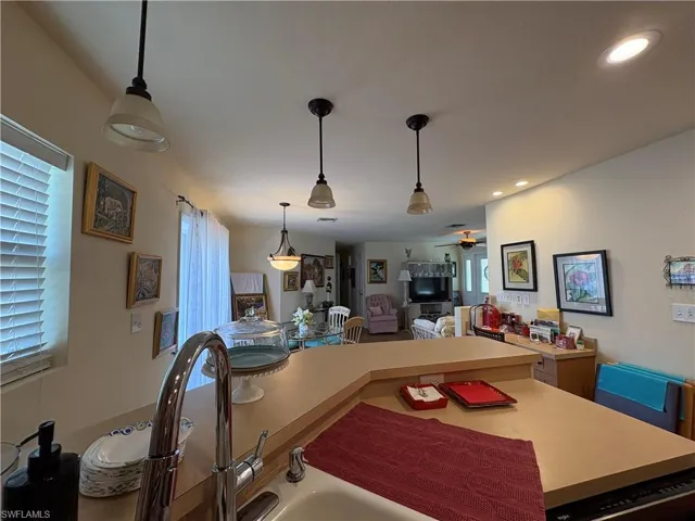 Kitchen with light countertops, decorative light fixtures, healthy amount of natural light, ceiling fan, and recessed lighting