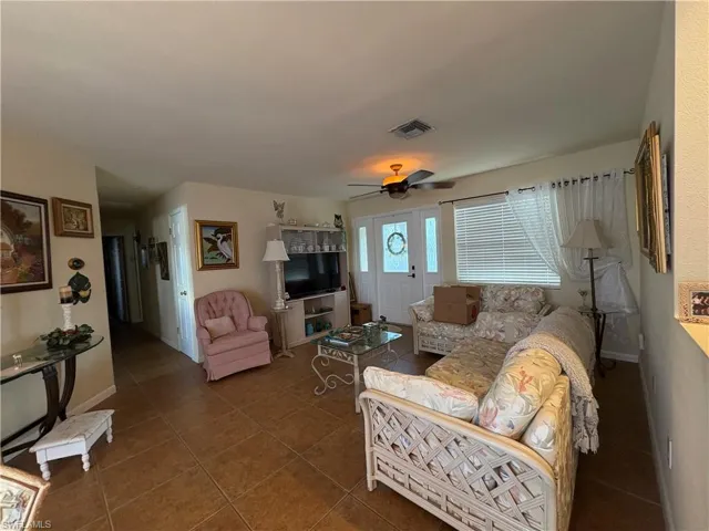 Living room with tile patterned floors and ceiling fan