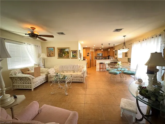 Living area featuring light tile patterned flooring, recessed lighting, and a ceiling fan
