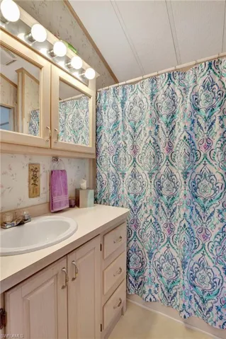 Bathroom featuring vanity, a textured ceiling, and curtained shower