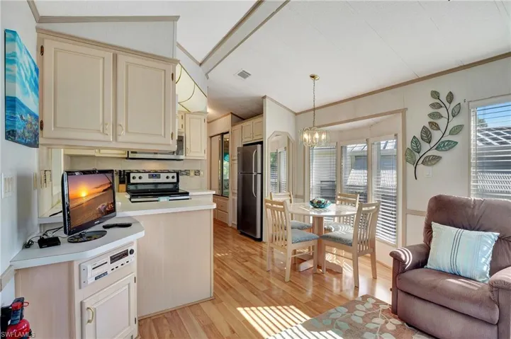 Kitchen with decorative light fixtures, stainless steel appliances, plenty of natural light, and light hardwood / wood-style flooring