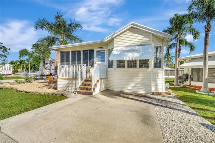 View of front of home with a front yard and a sunroom
