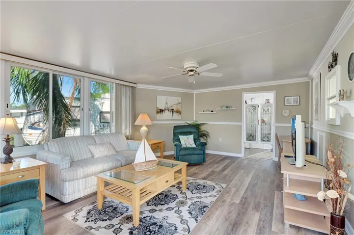 Living room featuring ceiling fan, hardwood / wood-style flooring, and ornamental molding
