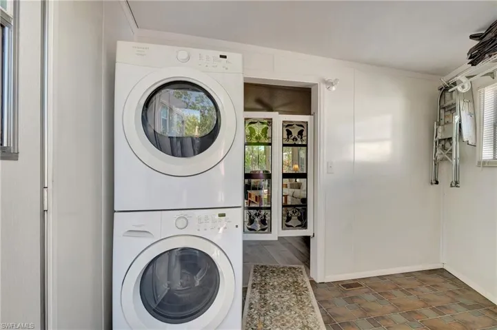 Washroom with stacked washer and clothes dryer and ornamental molding