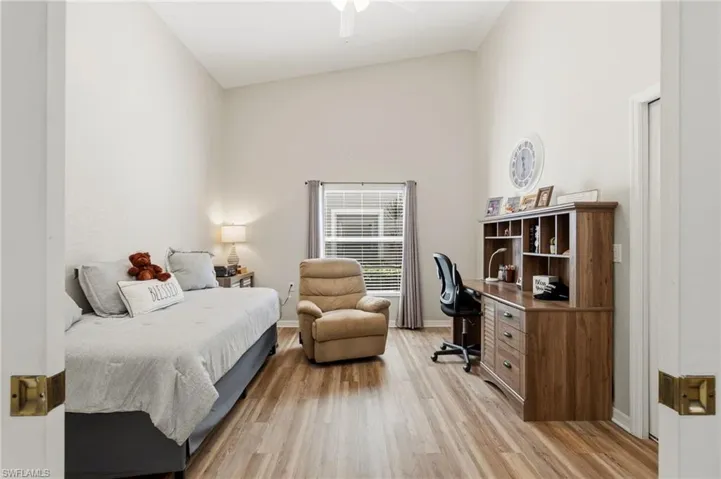 Bedroom featuring light wood-type flooring, high vaulted ceiling, a ceiling fan, and a desk