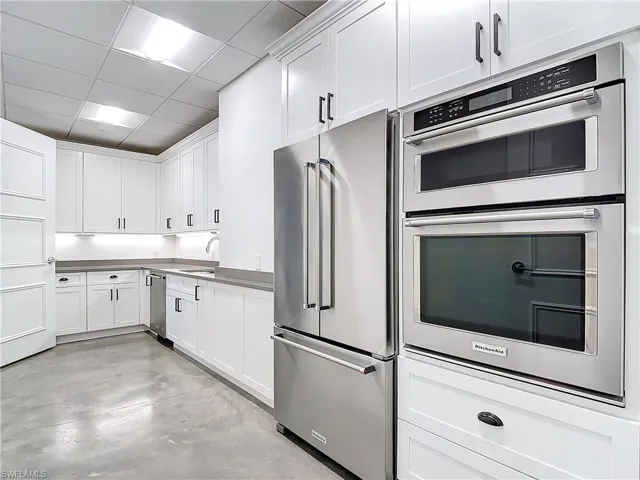 Kitchen with white cabinetry, stainless steel appliances, a paneled ceiling, and sink