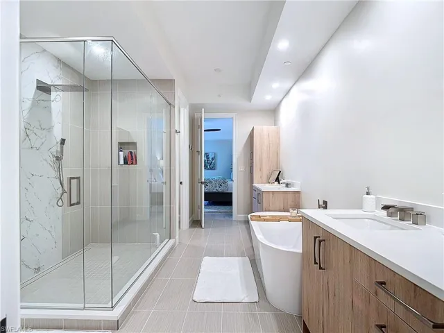 Bathroom featuring vanity, independent shower and bath, and tile patterned flooring