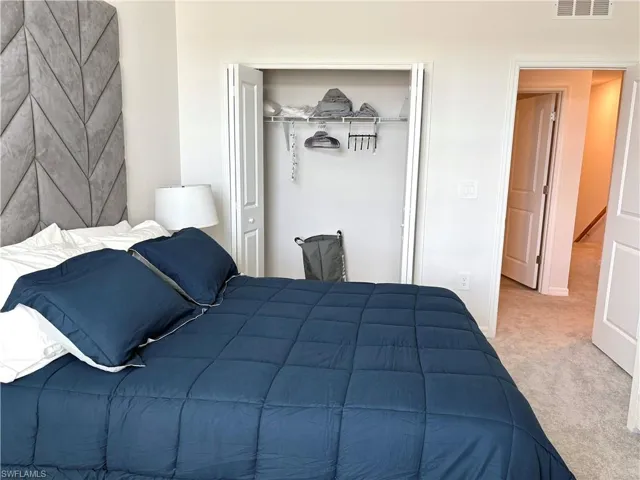 Carpeted bedroom featuring a closet