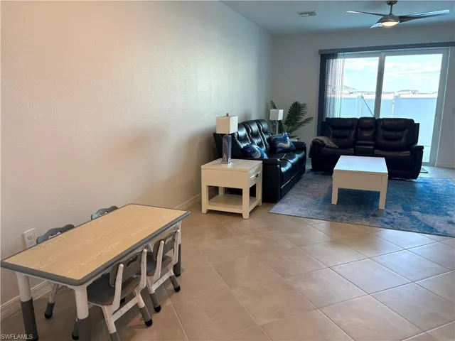 Living room with ceiling fan and light tile patterned floors