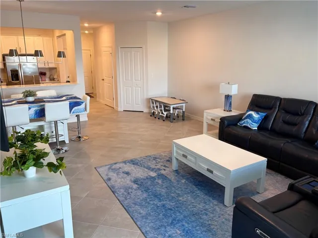 Living area with light tile patterned floors and baseboards