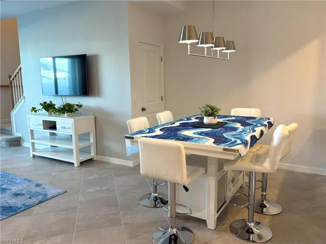 Dining room featuring stairs and light tile patterned floors