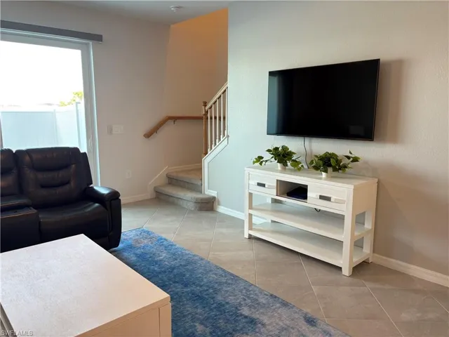 Living room with stairs and light tile patterned floors