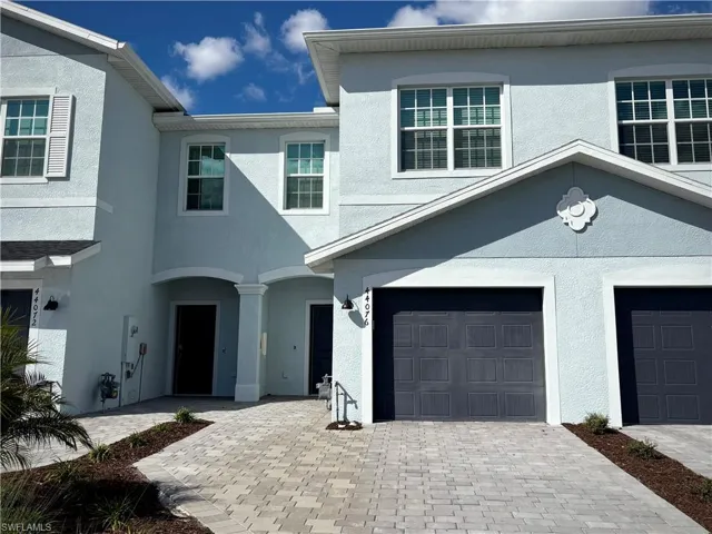 View of front of home featuring driveway, stucco siding, and a garage
