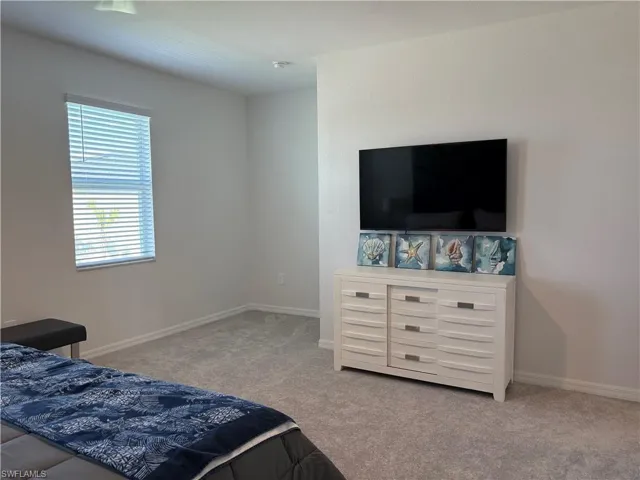 Bedroom with light carpet and baseboards