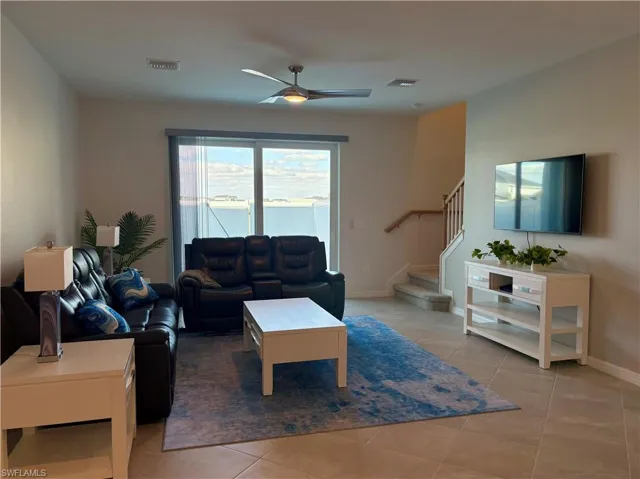 Living room featuring a ceiling fan and light tile patterned floors
