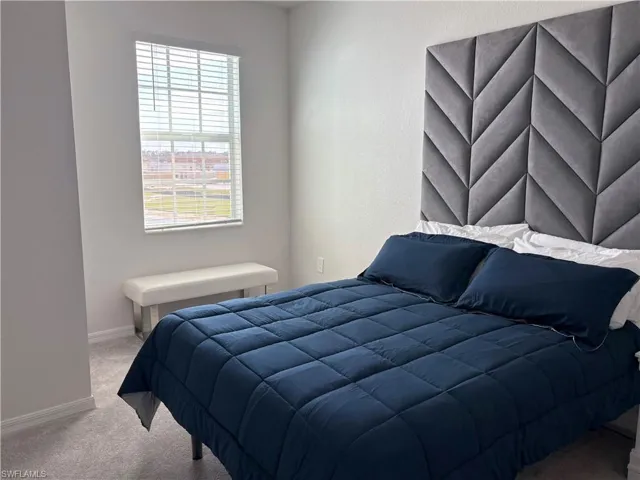 Bedroom with light carpet and baseboards