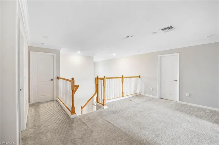 Unfurnished room featuring crown molding and light colored carpet
