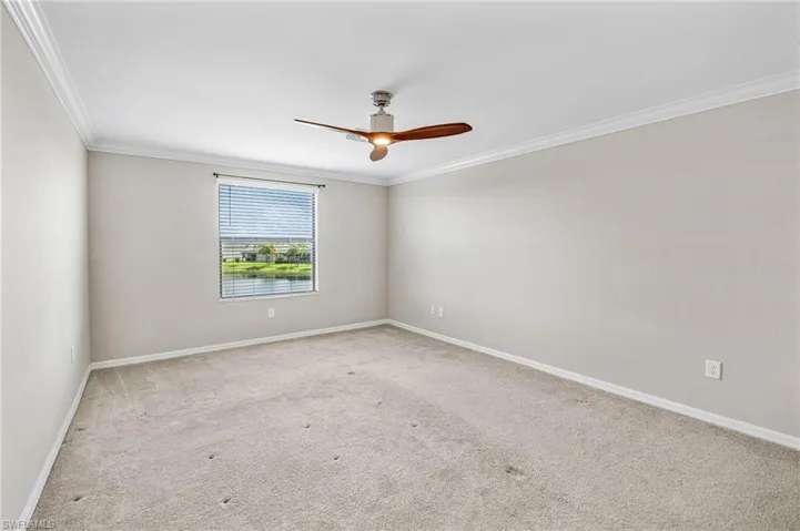 Carpeted empty room with ornamental molding and ceiling fan