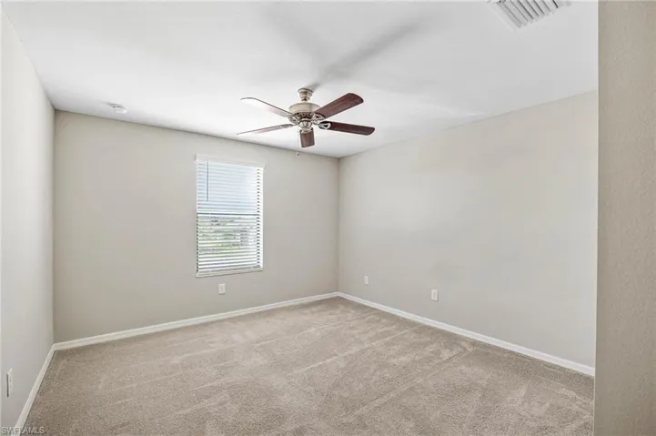 Carpeted spare room featuring ceiling fan